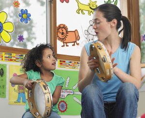 Teacher and child playing tambourine